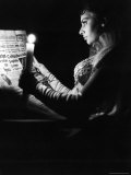 Actress Sophia Loren Reading Newspaper by Candlelight While in Costume for "Madame Sans Gene"