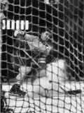 Ice Hockey Player Jean Believeau  Hitting a Puck Into the Goal