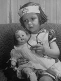 Evelyn Mott playing Nurse with doll as parents adjust children to abnormal conditions in wartime
