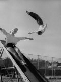 Acrobat and Actor Russ Tamblyn Doing a Flip at a Playground with Movie Actress Venetia Stevenson