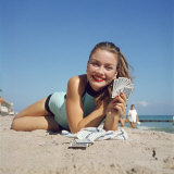 Model Holding Hand of Playing Cards While Relaxing on Beach