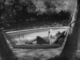 Greer Garson Reading While Relaxing in a Hammock Near Her Pool at Home