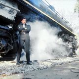 Country Music Star Johnny Cash Wearing Black Clothing and Standing in Front of a Locomotive