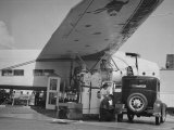 Service Attendant Pumping Gasoline Into Ford Sedan as Woman Watches at Gas Pumps