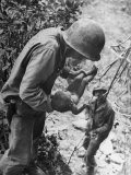 American Lieutenant Carrying Micronesian Baby He Found in cave Japanese Soldiers Holed Up There