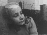 Girl Gazing Pensively Through Pane of Her Apartment Window  Grimly Reflects Image of Berlin Wall