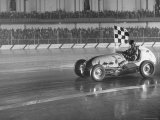 Track Record Holder Ted Tappett Circling Track With Checkered Flag After Winning
