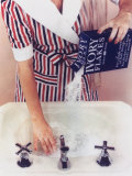 Woman in Red  White and Blue Robe Pouring Ivory Soap Flakes Into Bathroom Sink