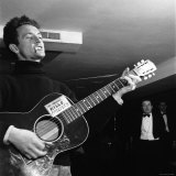Folk Singer Woody Guthie Performing with Guitar Emblazoned with "This Machine Kills Fascists"