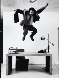 Architect and Designer Frank Gehry Jumping on a Desk in His Line of Cardboard Furniture