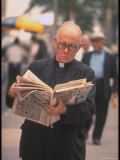 Episcopalian Priest Reading a Newspaper While Walking in Street  New York City