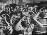 Classroom Full of Students Circling Fingers Around Eyes in Form of Glasses During Music Class