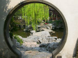 Zig Zag Stone Bridge and Willow Trees Through Moon Gate  Chinese garden  China