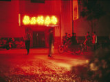 Motorcyclists outside a Karaoke Bar with a Neon Sign in Hunan