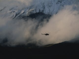 A Silhouetted Helicopter Flies over a Smoldering Crater