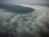 Small Plane Dwarfed by an Immense Cloud Formation