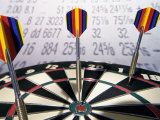 Darts on a Dartboard with Stock Figures in the Background