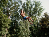 A Young Boy Takes a High Arc on a Rope Swing