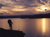 A Hiker Pauses for Reflection Alongside Lake Powell at Sunset