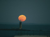 A Lighthouses Silhouette against a Full Moon