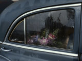 A Floral Arrangement Seen Through the Rain-Spattered Window of a Car