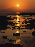 A Sunset on a River with Mountains in the Background
