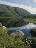 Mountains and Clouds are Reflected in Still Waters in This Landscape