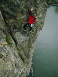 A Man Climbs Above a Canoe in the River