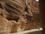A Hiker is Dwarfed by the Sandstone Walls of a Utah Canyon