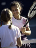 Two Girls Shaking Hands over the Net at a Tennis Court