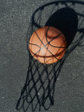 Close-up of a Basketball Resting on The Shadow of a Basketball Hoop