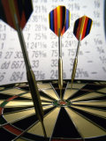 Darts on a Dartboard with Stock Figures in the Background