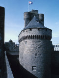 Gray Stone Castle Turret Against Blue Sky with French Flag in France