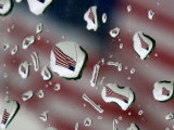 A Flag at a Lawrence  Kan  Restaurant is Refracted in Rain Drops on a Car Window