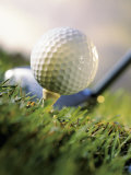 Golf Ball on Wooden Tee with Driver in Background