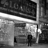 A Policeman Stands in Front of a Pawn Shop