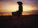 A Snack and Cigarette Vendor in a Straw Hat on the Beach at Dusk