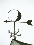 A Man-In-The-Moon Weather Vane on a Roof Top