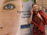 A Woman Uses a Mobile Phone While Waiting at a Bus Stop