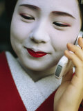 A Kimono-Clad Geisha Talks on a Cell Phone