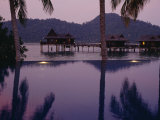 Reflections in a Pool and Traditional Malaysian Houses on Stilts