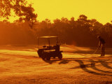 Man and Golf Cart Silhouetted at Sunset