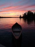 Canoe Floating in Lake During Sunset