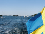 Swedish Flag with Sailboats in the Background  Stockholm Archipelago  Sweden