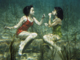 Performing swimmers put on lipstick underwater