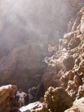 A Crowd Forms at the Base of a Ladder up a Steep Cliff