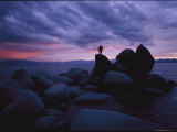 A Man Stands on a Large Rock Jutting out into the Harbor