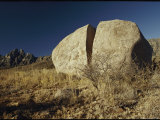 A Huge Boulder That is Split in Half Rests on a Grassy Knoll