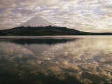 View of Snowcapped Payachata Volcano and a Cloudy Twilight Sky Mirrored in the Lake