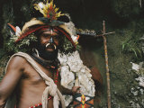 Elaborate Headdress and Boar Tusks Decorate the Face of a Tribesman